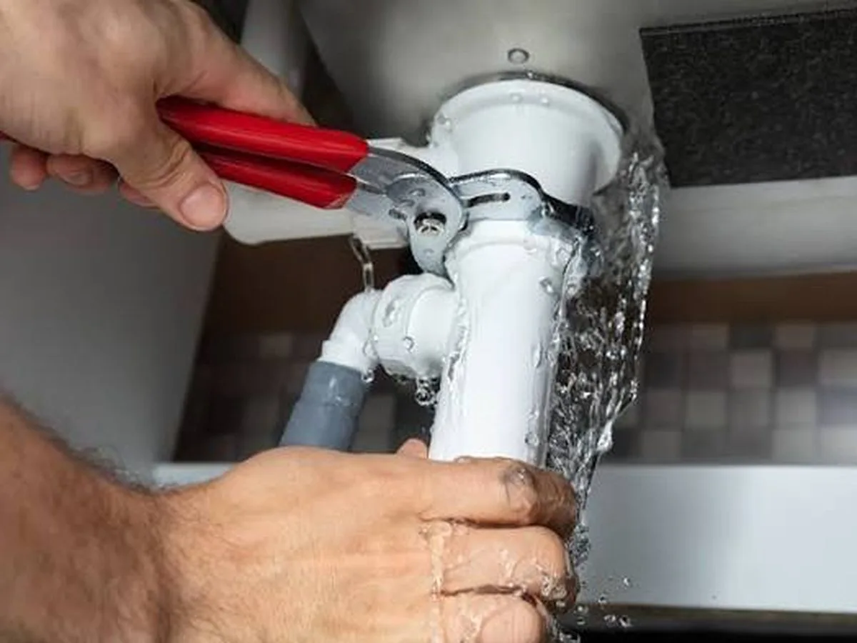 Burst copper pipe spraying water — plumbing emergency